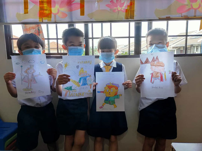 Kids at Q Garden showing off their creative drawings of the Monkey King